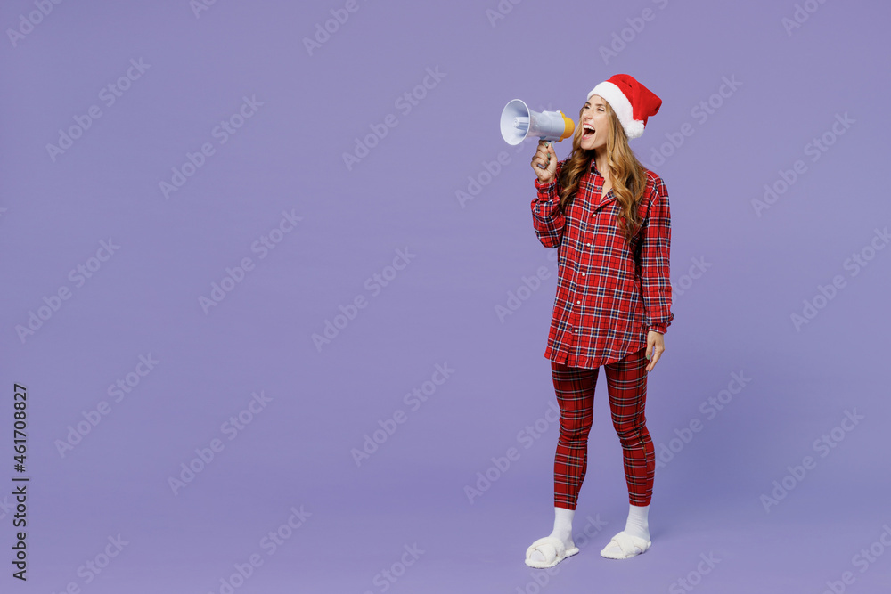 Obraz premium Full size body length fun young Santa woman 30s wears shirt Christmas hat hold scream in megaphone isolated on plain pastel light violet background studio portrait. Happy New Year celebration concept.