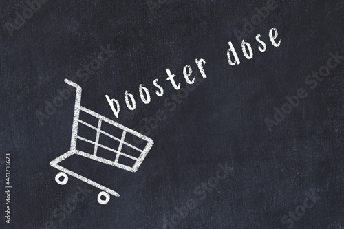 Chalk drawing of shopping cart and word booster dose on black chalboard. Concept of globalization and mass consuming photo