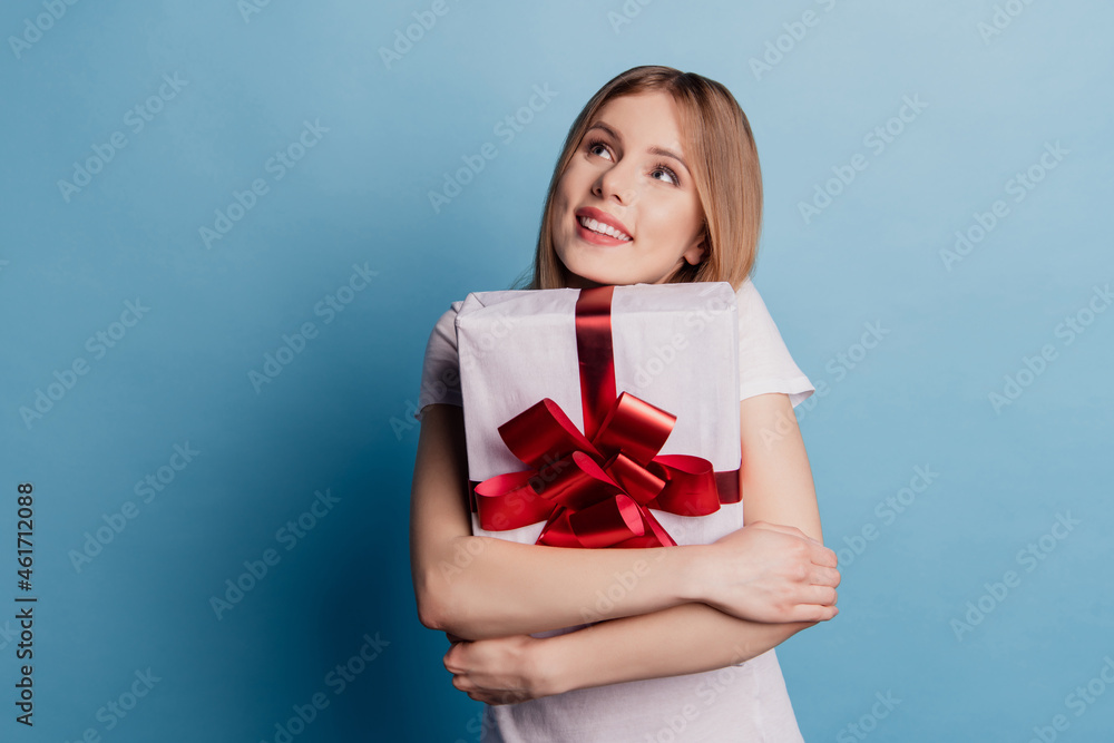 Photo of dreamy adorable blonde lady cuddle special gift look up empty space dream on blue color background Photo of dreamy adorable blonde lady cuddle special gift look up empty space dream on blue color background