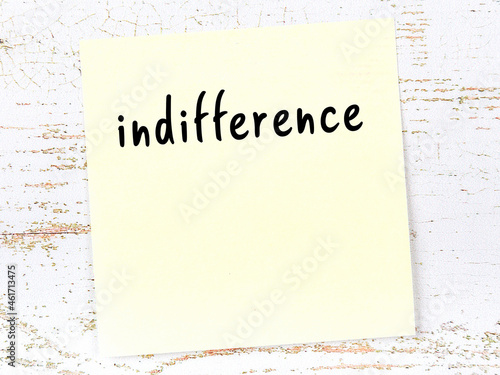 Fotografie Yellow sticky note on wooden wall with handwritten word indifference