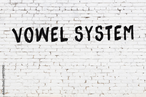 Inscription vowel system painted on white brick wall photo