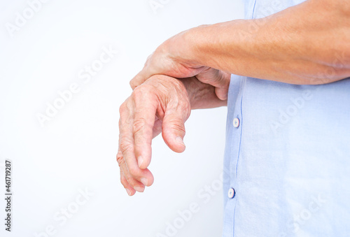 an old man support his arms which pain,numbness,weakness,paralysis (isolated on white background with copy space), concept of Guillain barre syndrome caused by autoimmune disorder.selective focus