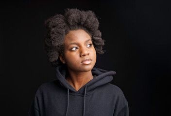 portrait of a young teen with black hoodies studio shot with black background