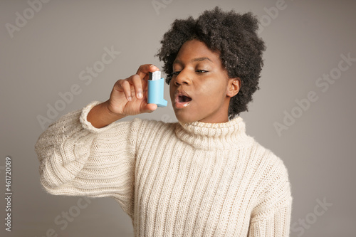Young African American teen with asthma inhaler photo