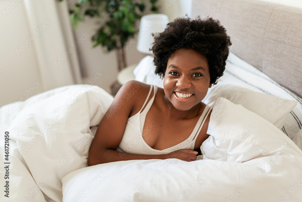 beautiful young African woman in tank top lying in bed beautiful young African woman in tank top lying in bed