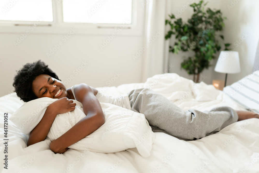 beautiful young African woman in tank top lying in bed beautiful young African woman in tank top lying in bed