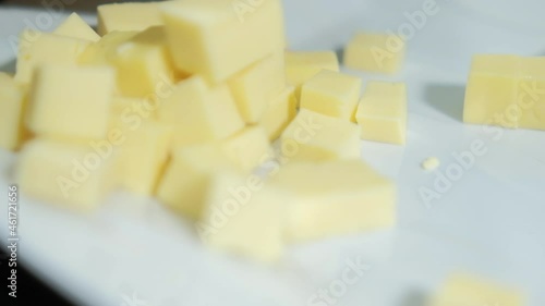 Fresh diced cheddar cheese on a white plate