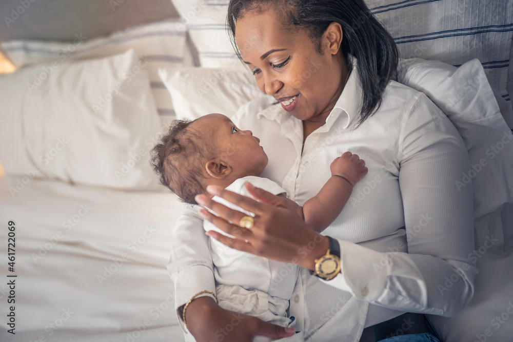 Obraz premium Happy mother with her baby boy at home in the bedroom