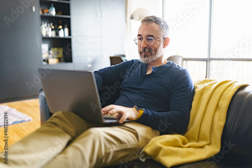 Portrait of handsome man with laptop on sofa