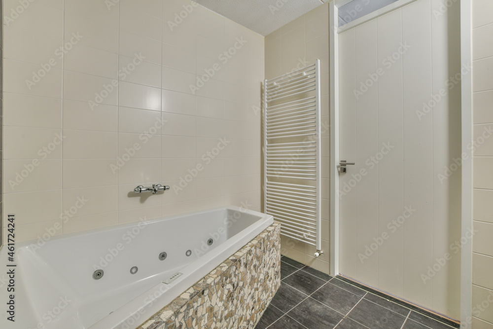 Interior of bathroom with bathtub and white heated towel rail Interior of bathroom with bathtub and white heated towel rail