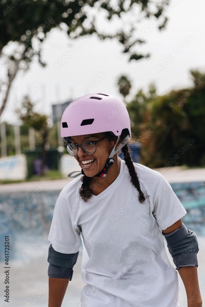 Cheerful African American woman in pink helmet and elbow pads Cheerful African American woman in pink helmet and elbow pads
