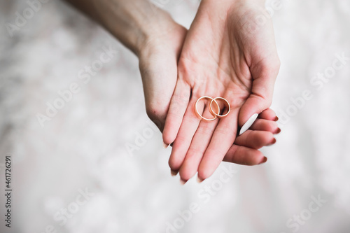 Beautiful luxury bride in elegant white dress holds wedding rings in the hands