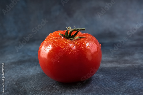 Ripe tomato with drops views on grunge background. photo