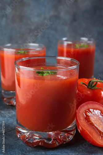Tomato juice in glasses. Blue vintage background. Rustic.