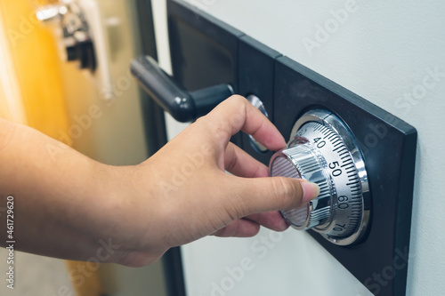 Close up of a women hand hold and tuning on a combinations safe dial lock
