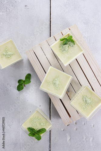 Photos Green Tea Pana cotta in a glass decorated with mint leaf.