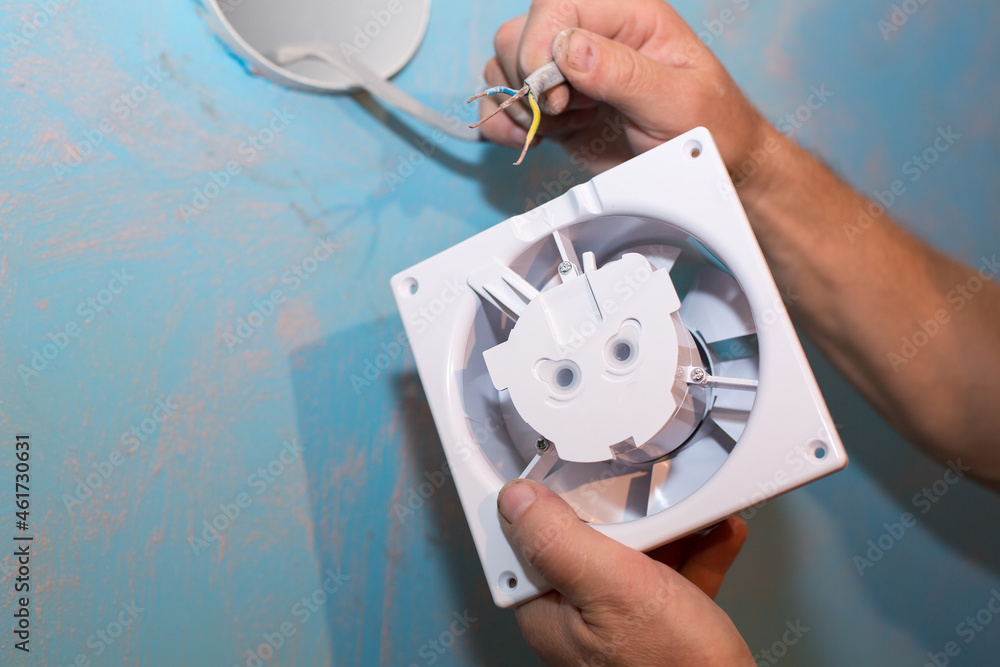 Man is installing the wall bathroom fan vent. Restoration process ...