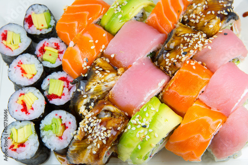 Tasty Colorful assorted Set of different type Sushi. Dinner in Japanese style. Healthy food. Filadelfia and Maki sushi rolls with Avocado, Tuna, Salmon, fish and Prawns. Close up view. Wallpaper.