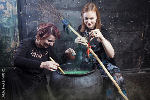 Young beautiful witches preparing a potion for Halloween 