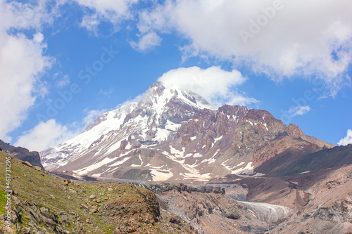 Mountain landscape with clouds and snow. View of Kazbek in the clouds from the Gergeti glacier © Юлия Ненадовец