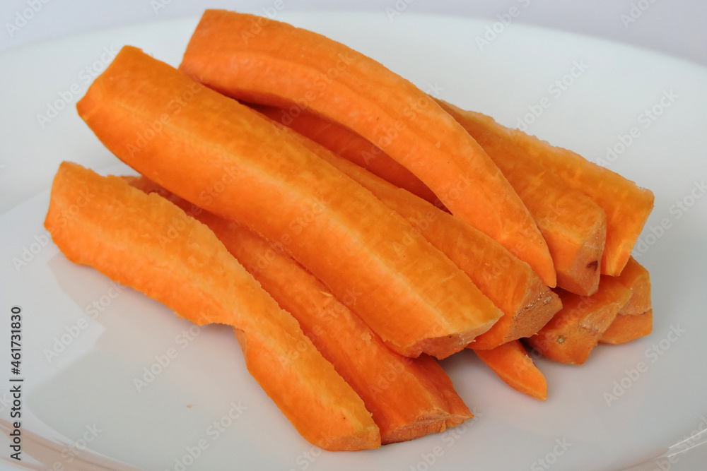 Orange carrot sticks on a white plate, white background Orange carrot sticks on a white plate, white background