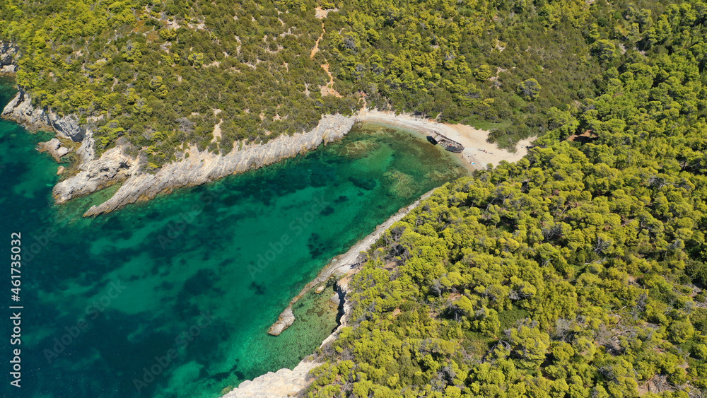 Aerial drone photo of famous small bay of Agalipa with crystal clear emerald sea featuring iconic wooden shipwreck left ashore, Skiros island, Sporades, Greece