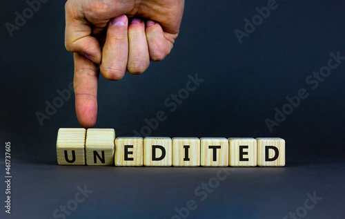 Edited or unedited symbol. Businessman turns wooden cubes and changes the word unedited to edited. Business and edited or unedited concept. Beautiful grey background, copy space.