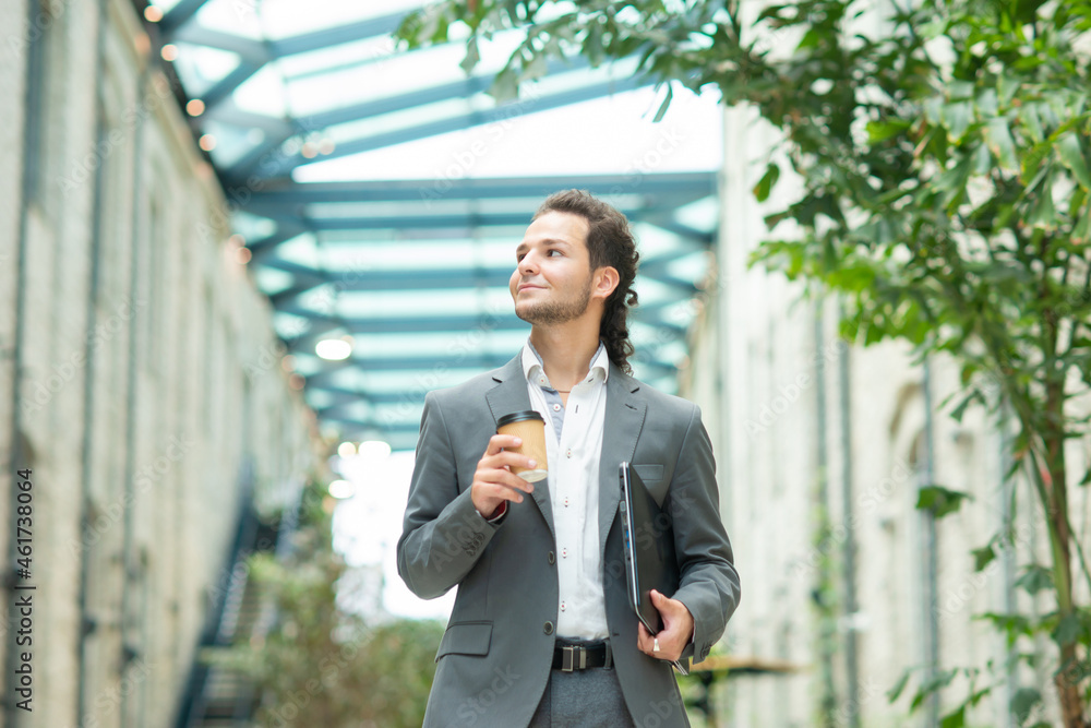 A young successful businessman is walking down the street. Man in a casual wear. Business, freelance and remote work. A young successful businessman is walking down the street. Man in a casual wear. Business, freelance and remote work.