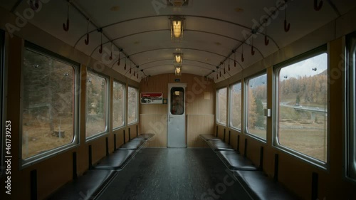 Interior of empty vintage train carriage slowly moving up hill of mountain. Retro old school travel in train. Vintage railway journey. Travel through bernina area in switzerland photo