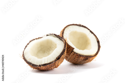 Two halves of a ripe coconut broken open to reveal the sweet flesh inside isolated on white