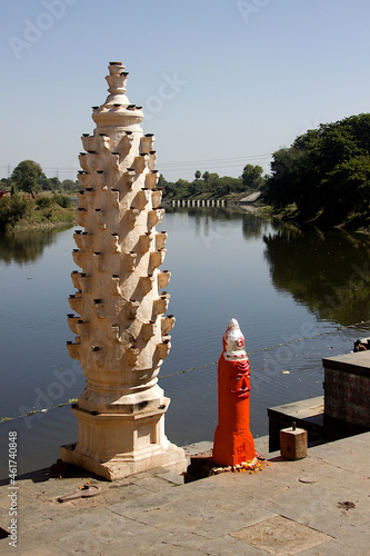 Stone lamp pillar with supports for placing earthen oil lamps on the bank of river Shipra India photo