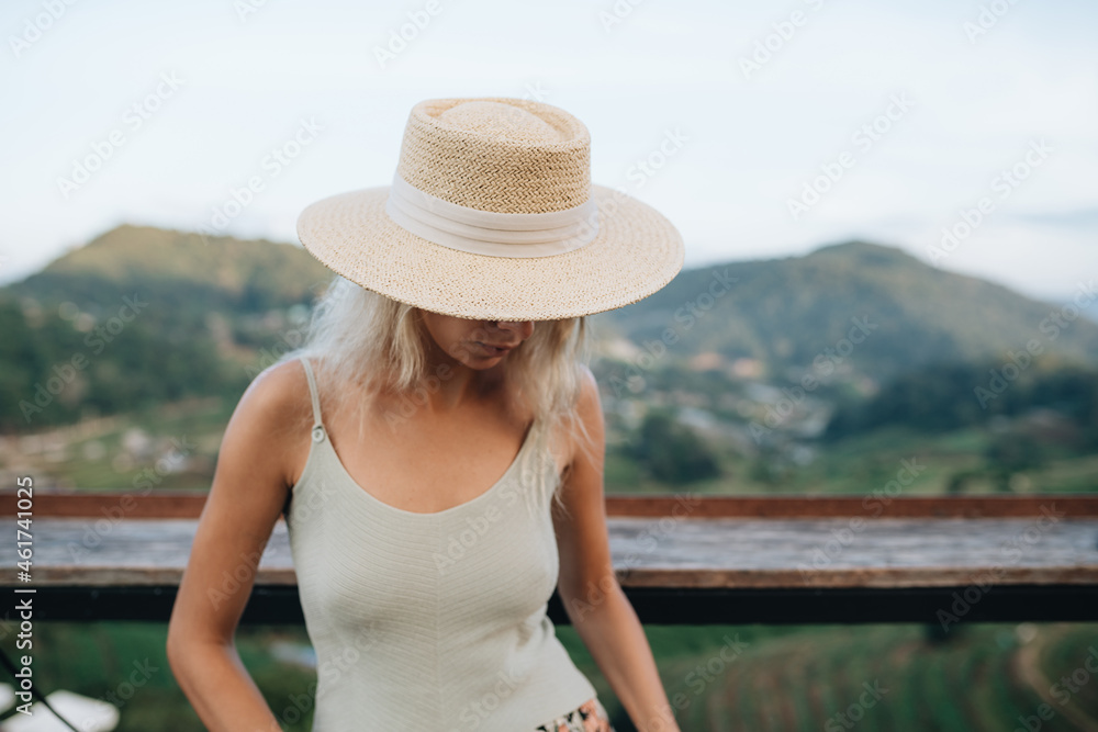 Portrait of a young woman in straw hat at viewpoint