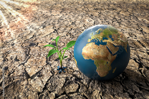 Obraz na płótnie Save Planet - Erde auf trockenem Boden mit sprießendem Pflänzchen in Pfütze w salonie