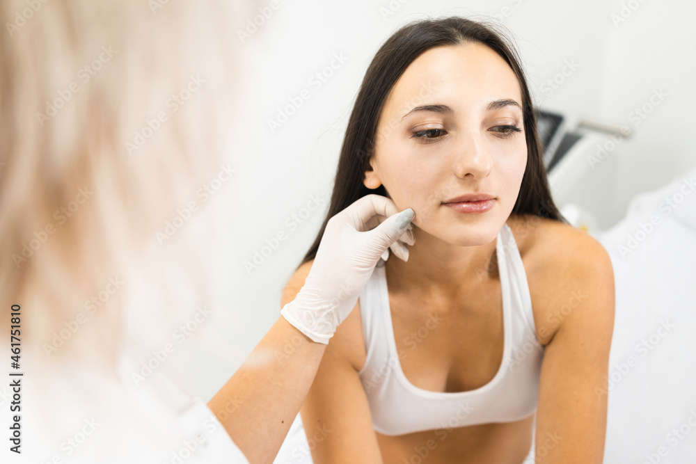 Doctor dermatologist examines moles on a woman's skin. Consultation before laser hair removal Doctor dermatologist examines moles on a woman's skin. Consultation before laser hair removal