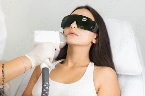 Laser hair removal for facial skin. Woman in epilation salon photo