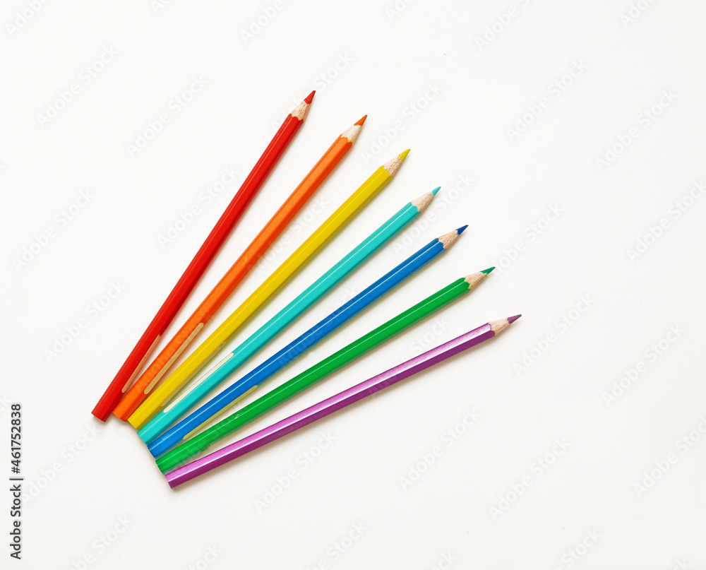 bright colorful pencils in the amount of seven pieces for drawing, lie on a white sheet of paper. bright colorful pencils in the amount of seven pieces for drawing, lie on a white sheet of paper.