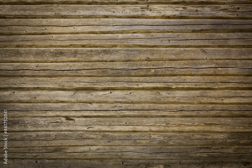 Naklejka premium Wooden logs of an old house. Close-up. Weathered natural gray wood texture. Background. Horizontal photo