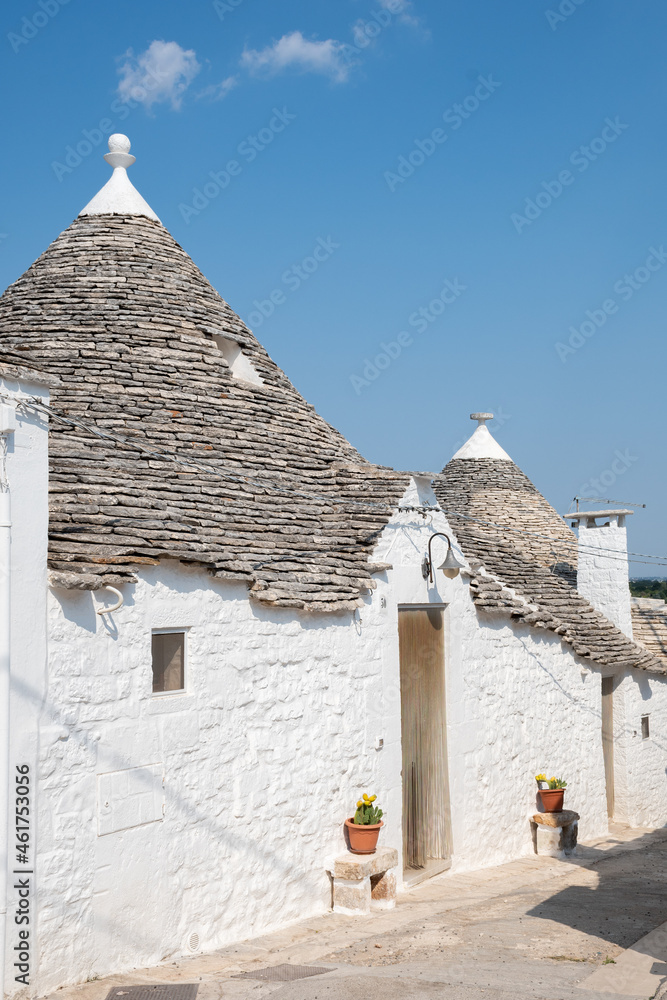 Group of beautiful Trulli, traditional Apulian dry stone wall hut old houses with a conical roof in Alberobello, Puglia, Italy, vertical