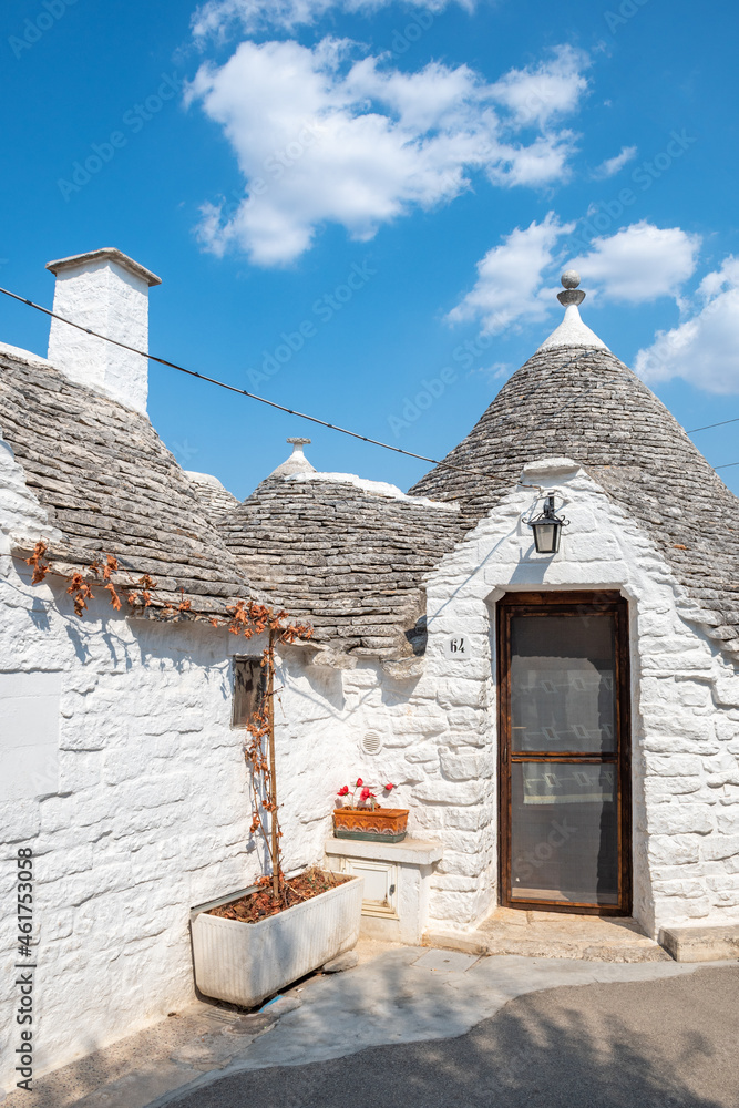 Group of beautiful Trulli, traditional Apulian dry stone wall hut old houses with a conical roof in Alberobello, Puglia, Italy, vertical