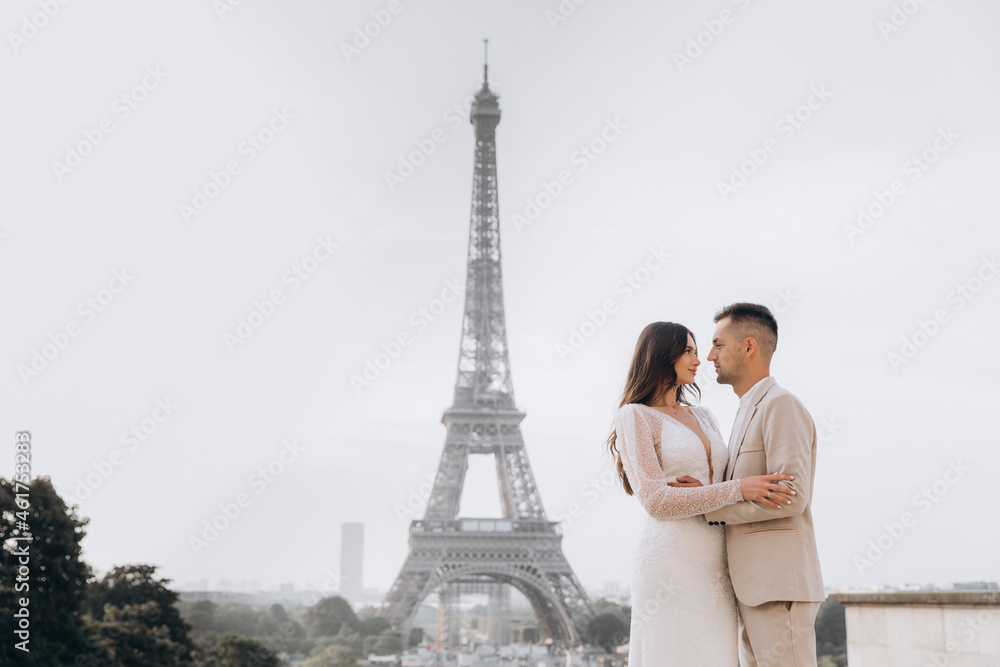 Happy young couple in love in the front of the Eiffel tower.