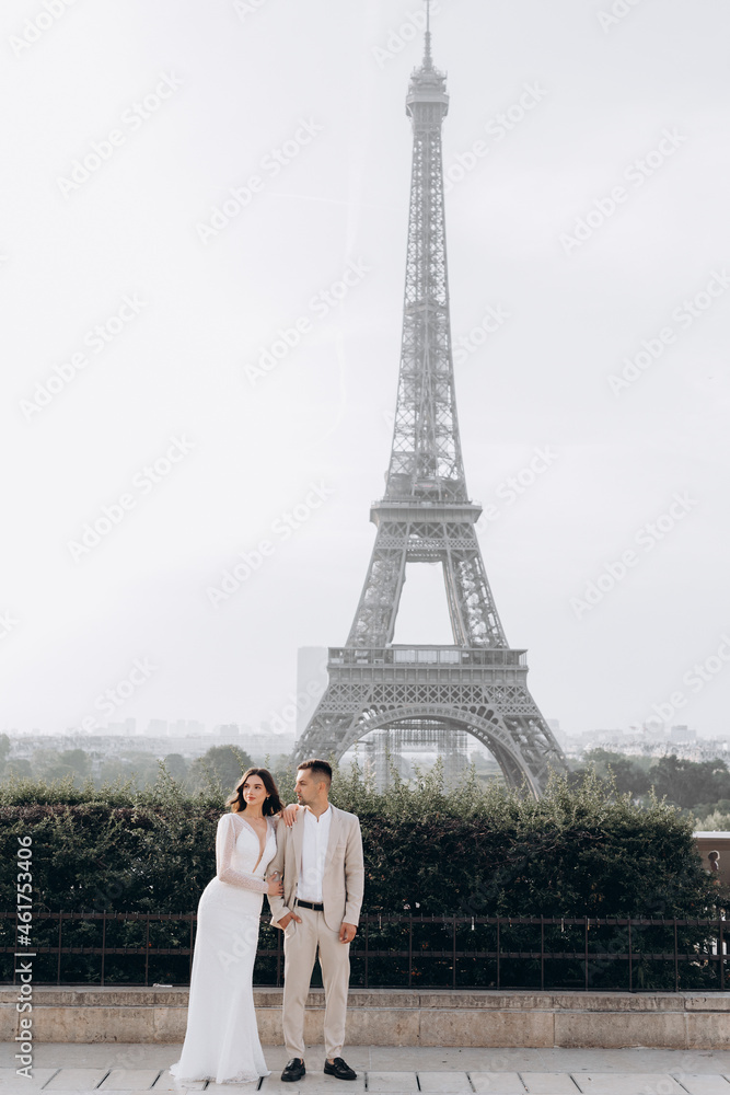 Married couple near the Eiffel tower on their wedding day. Bride and groom in Paris, France.