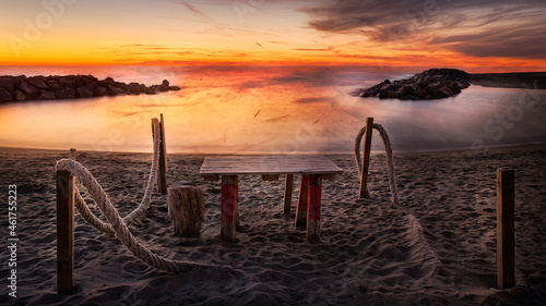 beach wooden table in a stunning sunset