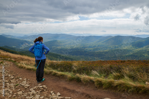 Bieszczady jesienią. Turyści na górskich szlakach. Dziewczyna spogląda w dal.Połoniny. Ciemne chmury. Korory jesieni.