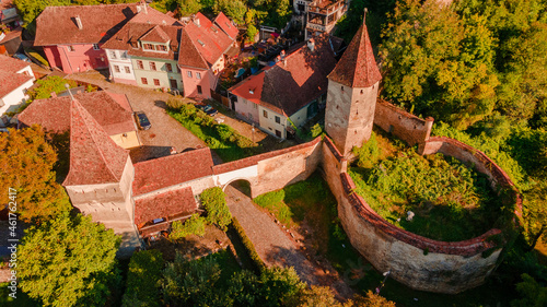 Aerial photography of a fortified gate with towers at medieval town of Sighisoara located in Romania. Aerial photography above a mdieval city with fortified walls and towers.