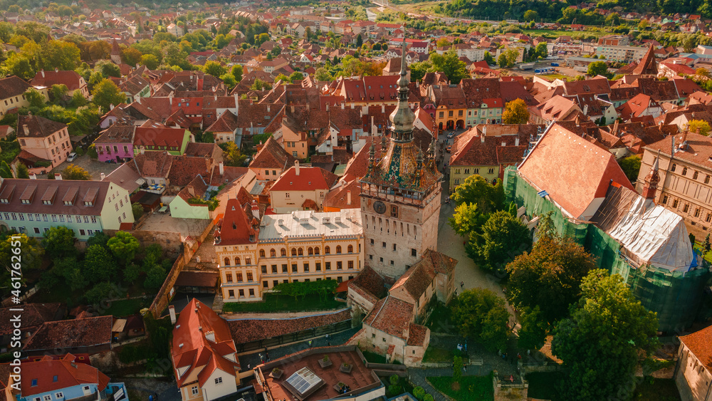 Naklejka premium Aerial photography of medieval city of Sighisoara from Romania, taken from a drone with the Clock Tower in the front. Birds eye view over Sighisoara city