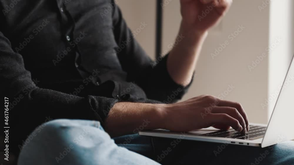 Close-up view of the serious businessman typing on a laptop and taking off his glasses Close-up view of the serious businessman typing on a laptop and taking off his glasses