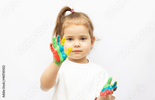 Cute girl showing her hands painted in bright colors, isolated over white