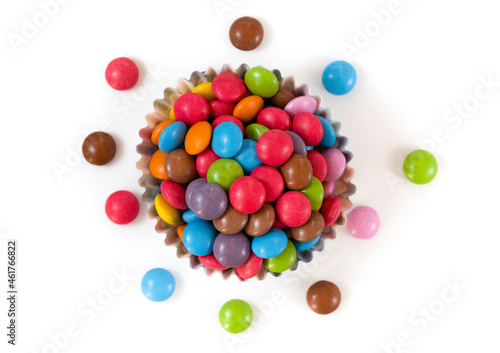 round colored candies in a glass plate on a white background.