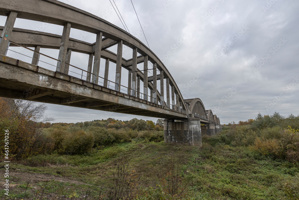 Old railway bridge over the river. Reinforced concrete bridge structure.