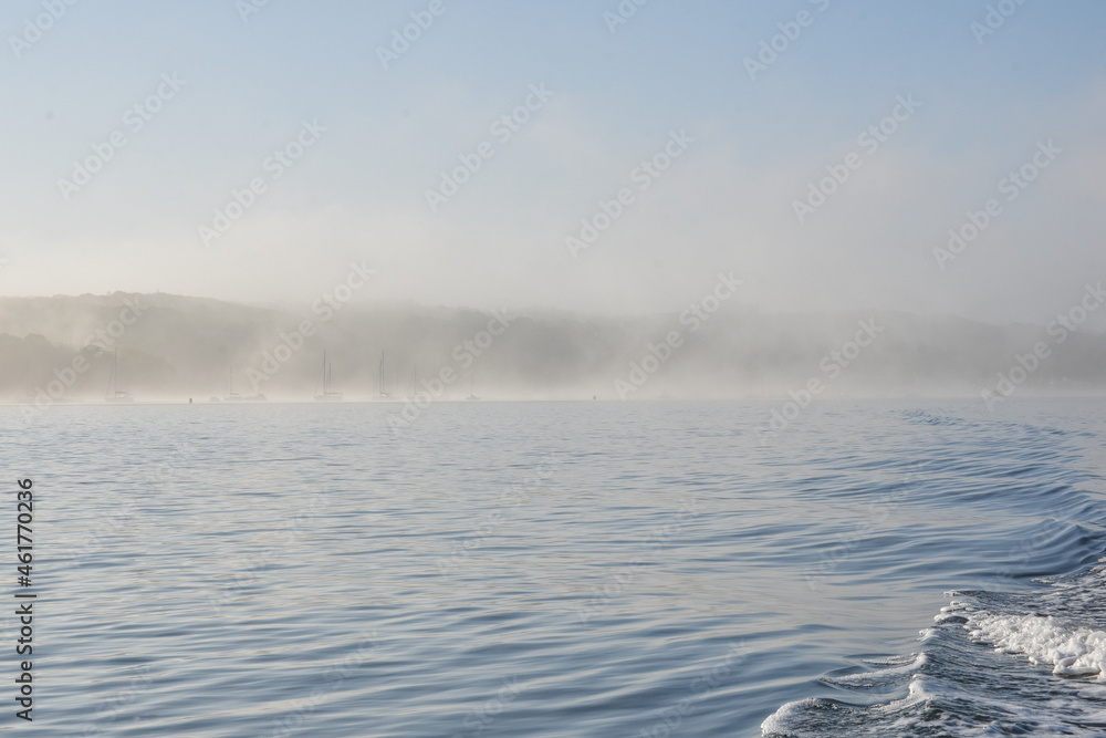 Early summer morning fog scene in Port Jefferson Harbor, Long Island, NY.  Copy space.	